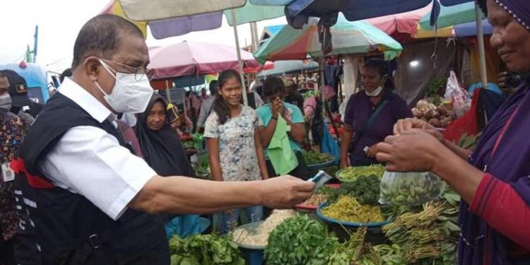 -	Walikota Ambon, Richard Louhenapessy sementara menyambangi seorang pedagang sayur pasar Arumabe Mardika Ambon untuk membeli sayur.
Foto : Istimewa
