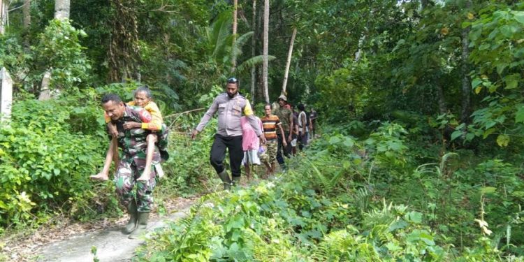 Foto suasana Nenek Patrisya sementara di Gendong oleh Serda Baltasar, Babinsa desa Alusi Kelaan dari hutan menuju Desa Alusi Kelaan, Rabu (27/07/2022) pada pukul 08.30 WIT. (Foto: Pendam 16 Pattimura)