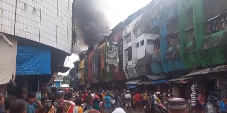 Keterangan Gambar : Pedagang Pasar Madika, Sirimau, Kota Ambon menyaksikan kebakaran salah satu ruko. Asap hitam mengepul. (Doc Istimewah)