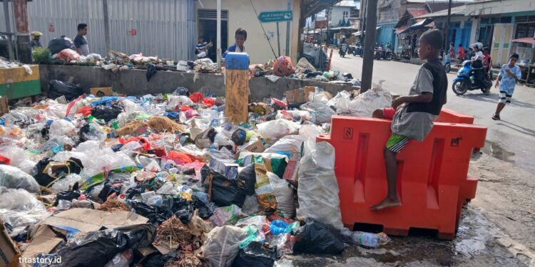 Keterangan gambar: Kondisi sampah yang tertumpuk di sekitar pasar Jargaria, Dobo. terlihat juga para bocah asik bermain di sekitar tumpukan sampah. (Foto: John)